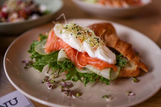 Mouthwatering croissant sandwich with fresh salmon, poached egg, and greens, perfect for brunch or lunch.